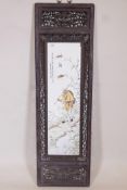 A Chinese polychrome porcelain panel in a carved and pierced hardwood frame, decorated with a