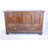 An C18th oak Lancashire mule chest, with plank top and carved frieze over four fielded panels and