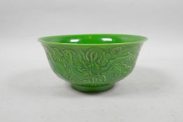 A Chinese apple green glazed porcelain rice bowl with raised dragon decoration, 6 character mark