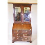 A Georgian walnut fall front bureau bookcase, the top section with mirrored doors opening to