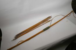A vintage wooden bow and a quantity of metal tipped arrows with feather flights, bow 60" long