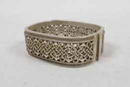 A Chinese white metal bangle with knotted decoration, 2" x 2½"