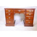 A Victorian walnut kneehole desk with nine moulded front drawers and brass handles, raised on a