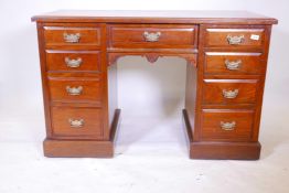 A Victorian walnut kneehole desk with nine moulded front drawers and brass handles, raised on a