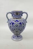 A German salt glazed pottery urn with scrolling blue foliate decoration, 11" high