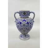 A German salt glazed pottery urn with scrolling blue foliate decoration, 11" high