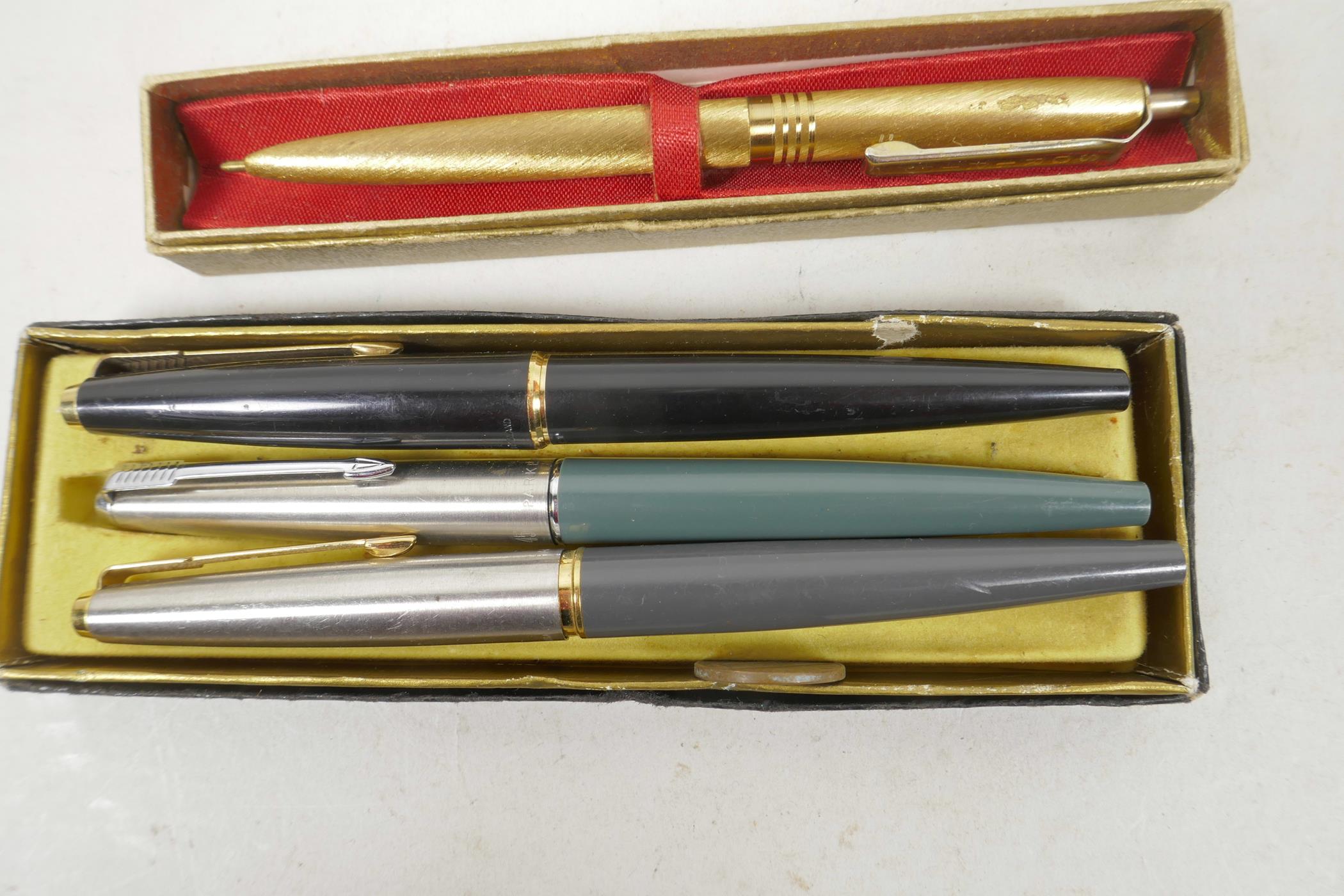 Three Parker fountain pens and a Scripto golden ball point pen