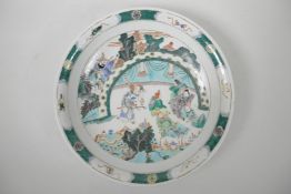 A Chinese famille verte porcelain charger decorated with figures in a landscape, 6 character mark to