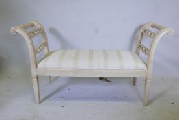 A painted wood window seat, with pierced ends, raised on square tapering supports, 56" x 19" x 31"