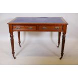 A Victorian walnut two drawer writing table, with inset rexine top and moulded decoration, raised on