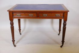 A Victorian walnut two drawer writing table, with inset rexine top and moulded decoration, raised on
