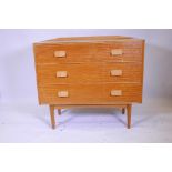 A mid C20th chest of three long drawers raised on ribbed tapered supports, 42" wide, 37" long, 13"
