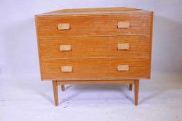A mid C20th chest of three long drawers raised on ribbed tapered supports, 42" wide, 37" long, 13"