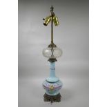 A blue glass lamp with a facet cut centre section and brass mounts, with pink floral swag