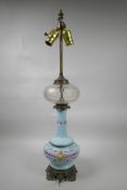 A blue glass lamp with a facet cut centre section and brass mounts, with pink floral swag