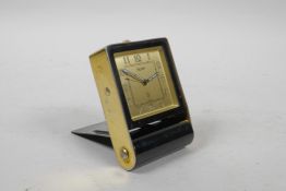 A Jaeger travelling alarm clock in a gilt and black metal case, with square gilt dial and Arabic