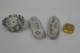 Two Chinese white metal ingots of lozenge form, another circular, and a gilt metal ingot, largest 4"