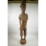 An African carved wood and dung mortar figure with shell and bead details, 40" high, A/F