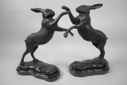 A pair of bronze figures of boxing hares, 12" high