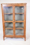 A C19th Continental kingwood two door display cabinet with marble top, raised on shaped supports,