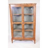 A C19th Continental kingwood two door display cabinet with marble top, raised on shaped supports,