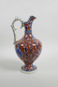 An early C20th Turkish Kutahya pottery ewer with traditional floral decoration, repair to handle,