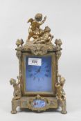 A C19th French style gilt bronze mantel clock, with winged putti decoration and inset enamelled