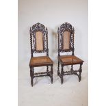 A pair of C19th French oak high back chairs with carved griffin decoration and caned seats and