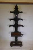 A C19th carved oak tree hall stand, with eight mushroom hat pegs, central mirror and lift up glove
