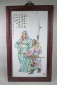 A Chinese polychrome porcelain panel decorated with two warriors in a hardwood frame, 21" x 35½"
