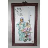 A Chinese polychrome porcelain panel decorated with two warriors in a hardwood frame, 21" x 35½"