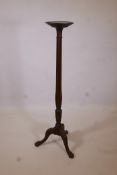 A C19th mahogany torchere with a ribbed column, carved tripod legs and ball and claw feet, 55" high,