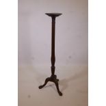 A C19th mahogany torchere with a ribbed column, carved tripod legs and ball and claw feet, 55" high,