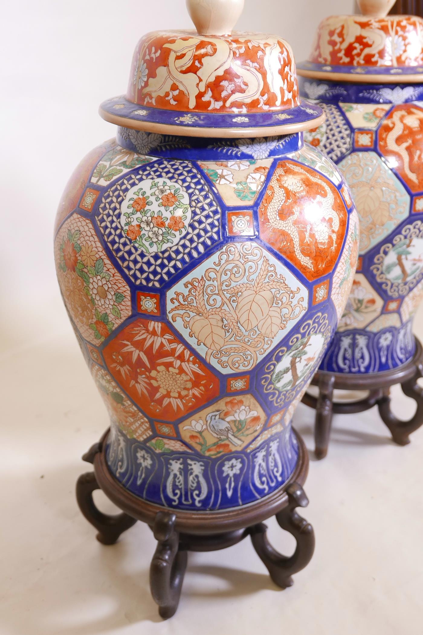 A pair of Oriental ceramic jars and covers, decorated with bright enamels in the Imari style, with - Image 3 of 5