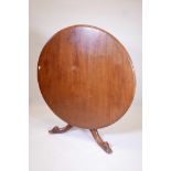 A mid C19th tilt top breakfast table in walnut, with circular top, on a solid turned central support
