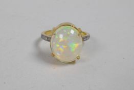 A silver gilt ring set with a large opal and diamond shoulders, approximate size 'P'