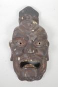 A Japanese carved and lacquered wood Oni mask, 15" long