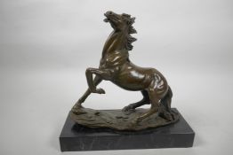 A bronze figurine of a horse posed with left foreleg raised after A.L. Barye, 9" high, mounted on