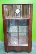 A mid C20th Hubbinet walnut corner display cabinet, with mirrored back and inset clock, and two