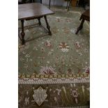 A wool carpet with oriental style design on a green and rust coloured field, 219" x 168"