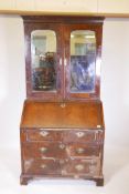 A Georgian walnut fall front bureau bookcase, the top section with mirrored doors opening to