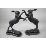 A pair of bronze figures of boxing hares, 12" high