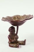 A Chinese bronze bowl designed as a seated boy holding a lotus leaf with frog, 2" high