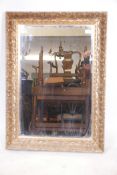 A gilt composition wall mirror with moulded reed and iris decoration, 26" x 36"