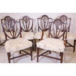 A set of six and one C18th Hepplewhite shield back dining chairs, with pierced splats and carved fan