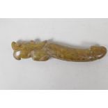 A Chinese carved hardstone phallic ornament with a dragon shaped handle, 8½" long