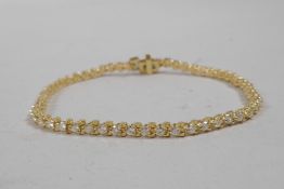 A 14ct yellow gold diamond line bracelet, 6" long, approximately 2.3cts