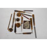 A quantity of tortoiseshell handled manicure tools and a tortoiseshell and silver panel