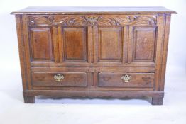 An C18th oak Lancashire mule chest, with plank top and carved frieze over four fielded panels and