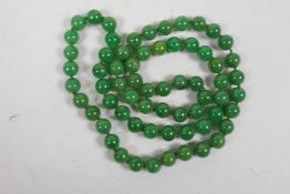 A long string of green jade beads, 32" long